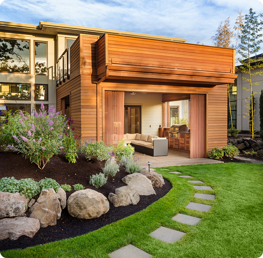 Modern wooden garden shed with stone pathway and green lawn.